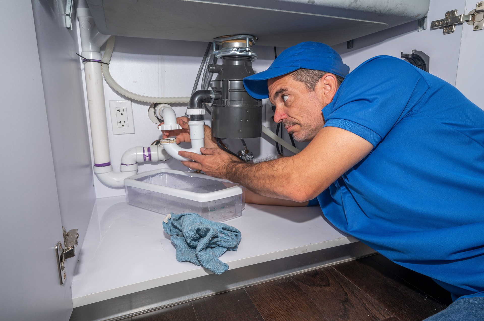Plumber working under a kitchen sink